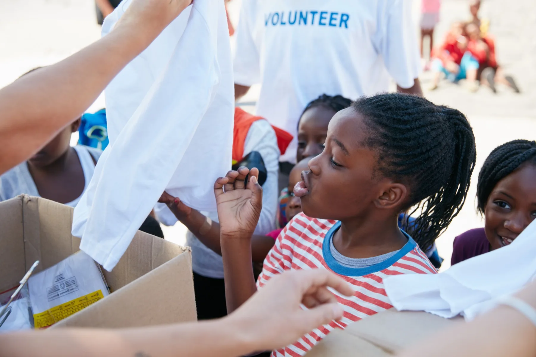 Children receiving donated clothing from volunteers